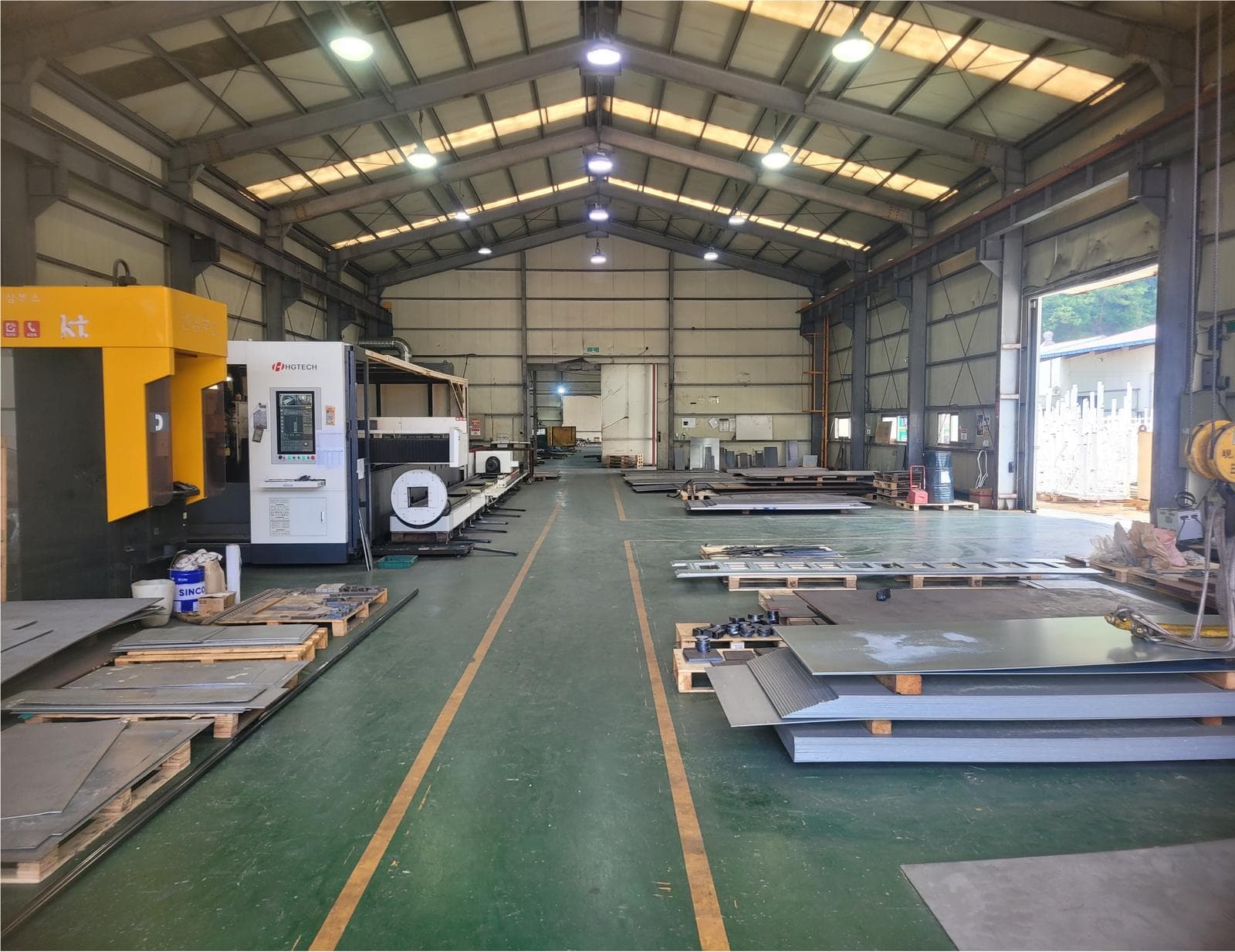 Inside a 3S factory: steel plate stock staged beside a laser cutting machine