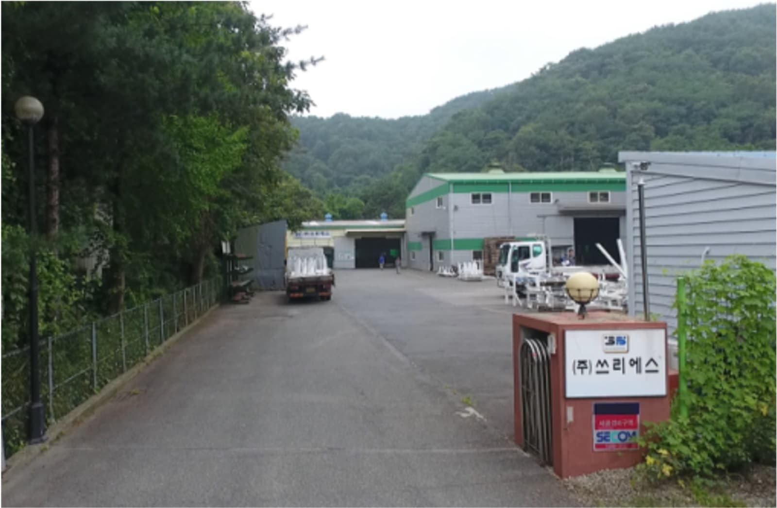 Entrance road to the 3S Uiryeong No.1 factory, with the company gate sign and production hall